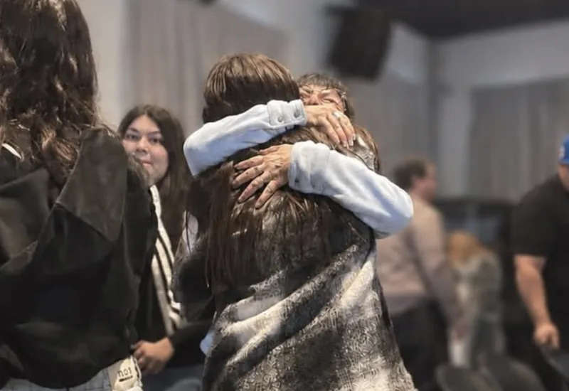 Dos personas abrazadas durante un encuentro de Amar Más.